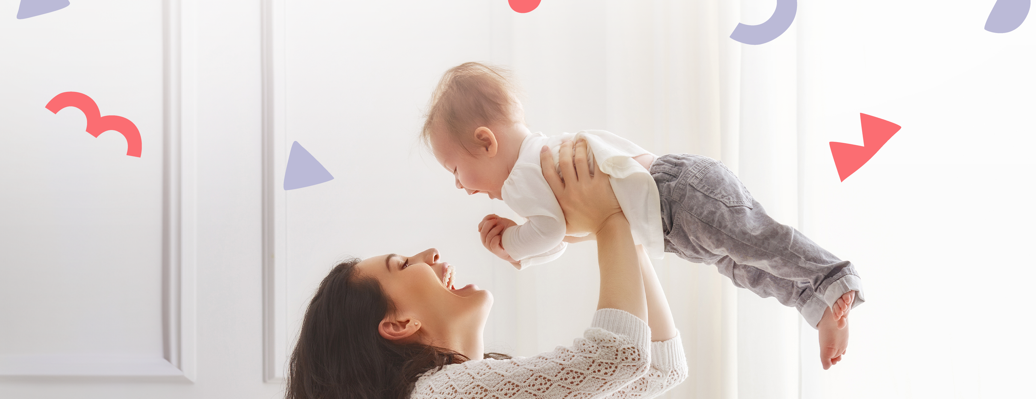 a happy mom picking up a happy baby with red and purple shapes floating in background