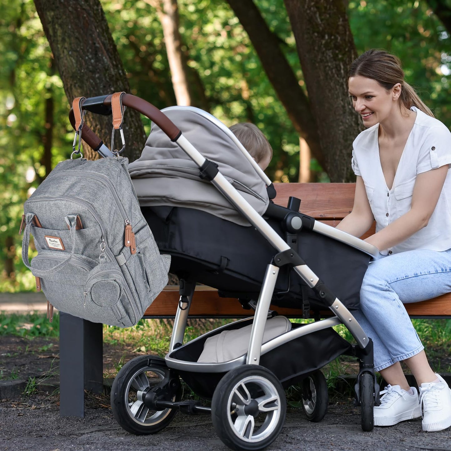 a person sitting on a bench with a baby in a stroller