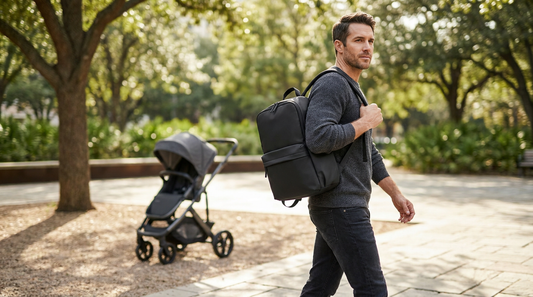 Dad confidently carrying a minimalist black diaper bag backpack — gender-neutral unisex design
