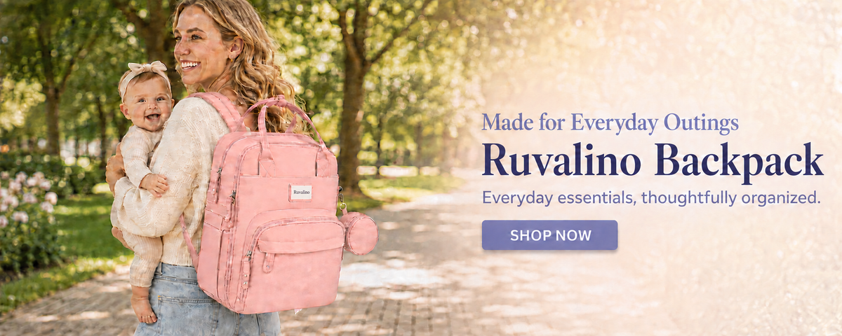 Mother carrying her baby with a pink Ruvalino diaper backpack in a park