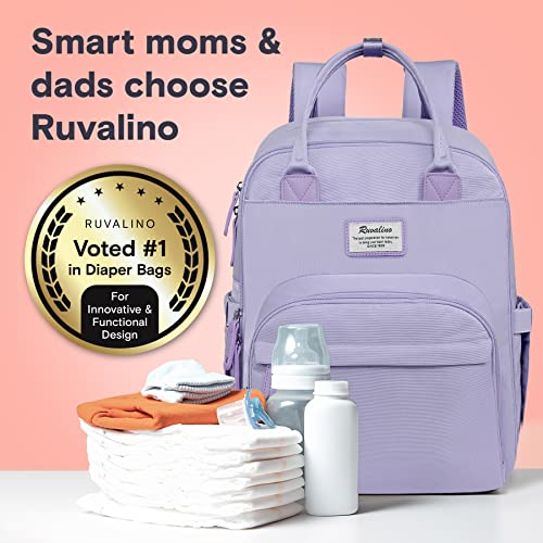 a purple backpack with baby items on a table with text: 'Smart moms & dads choose Ruvalino RUVALINO Voted #1 in Diaper Bags Fo Innovative & Functional Design'